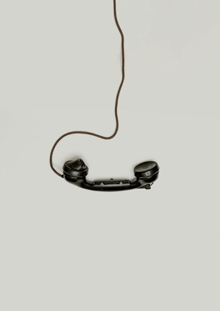 Black corded telephone handset left off the hook